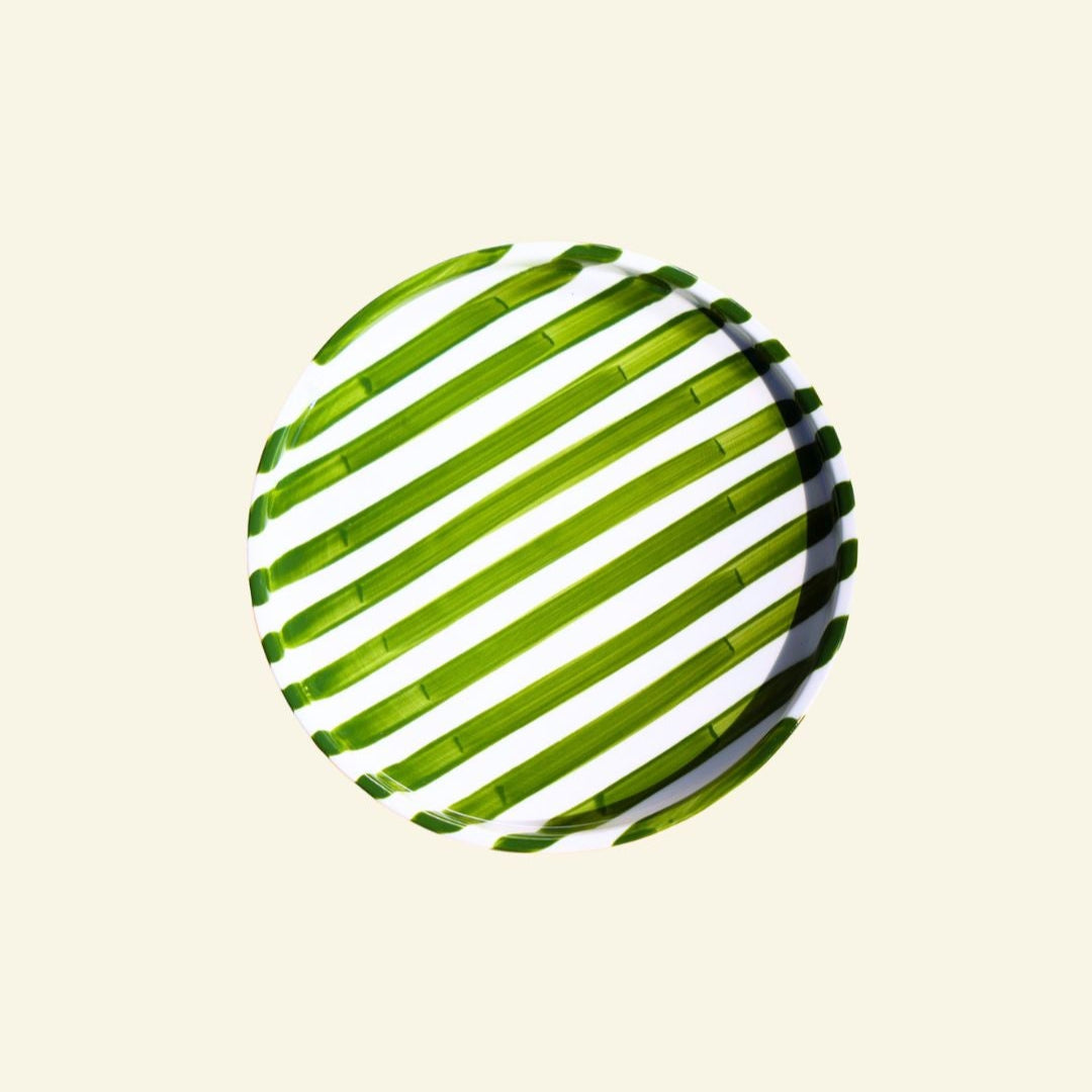 Green-White striped artisan handmade ceramic dinner plate on a beige background