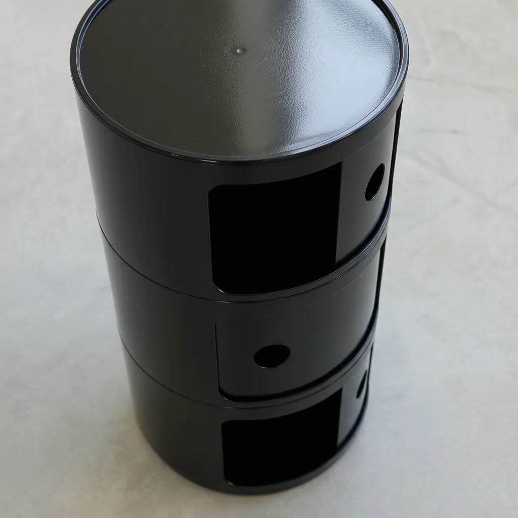 Black glossy round modular storage unit, Kartell Componibili dupe with three tiers in minimalist concrete studio