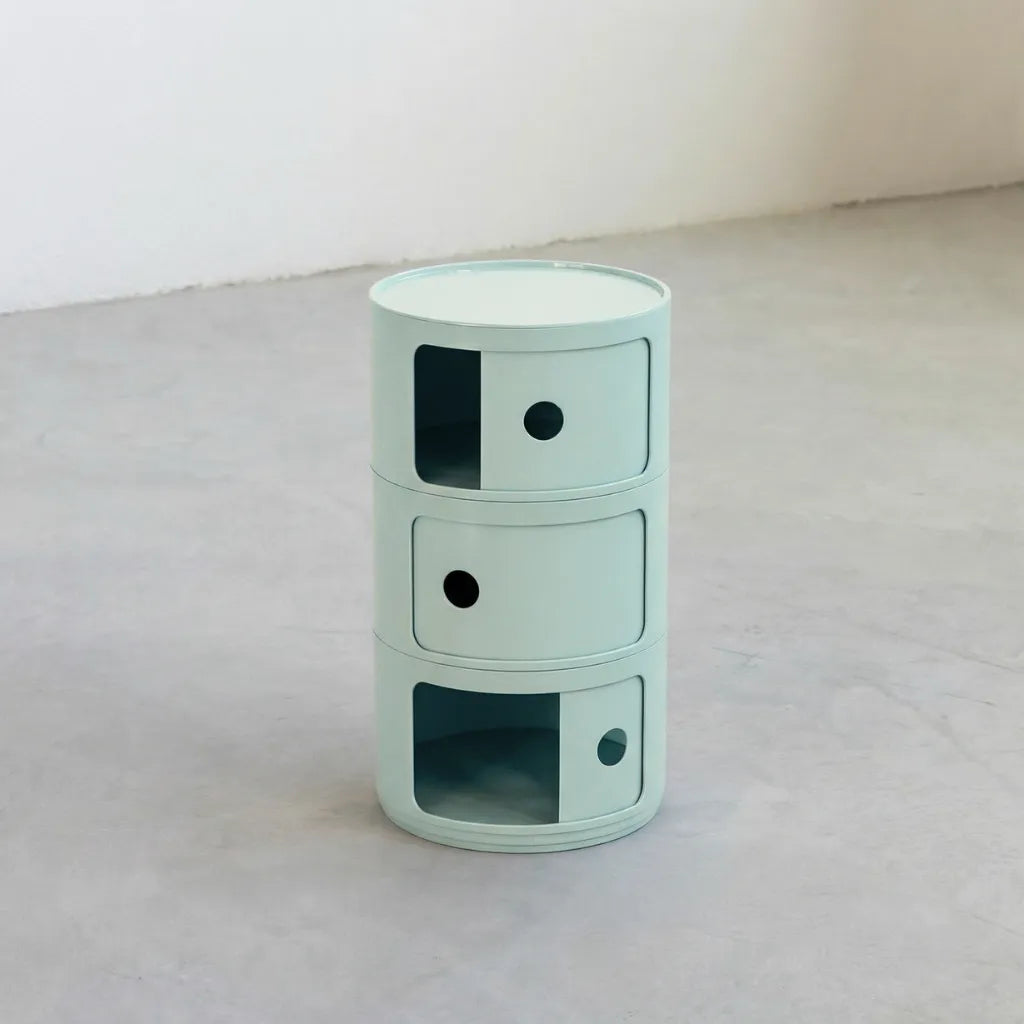 Kartell Componibili dupe round modular storage unit in light blue glossy plastic with three tiers on concrete floor in white studio
