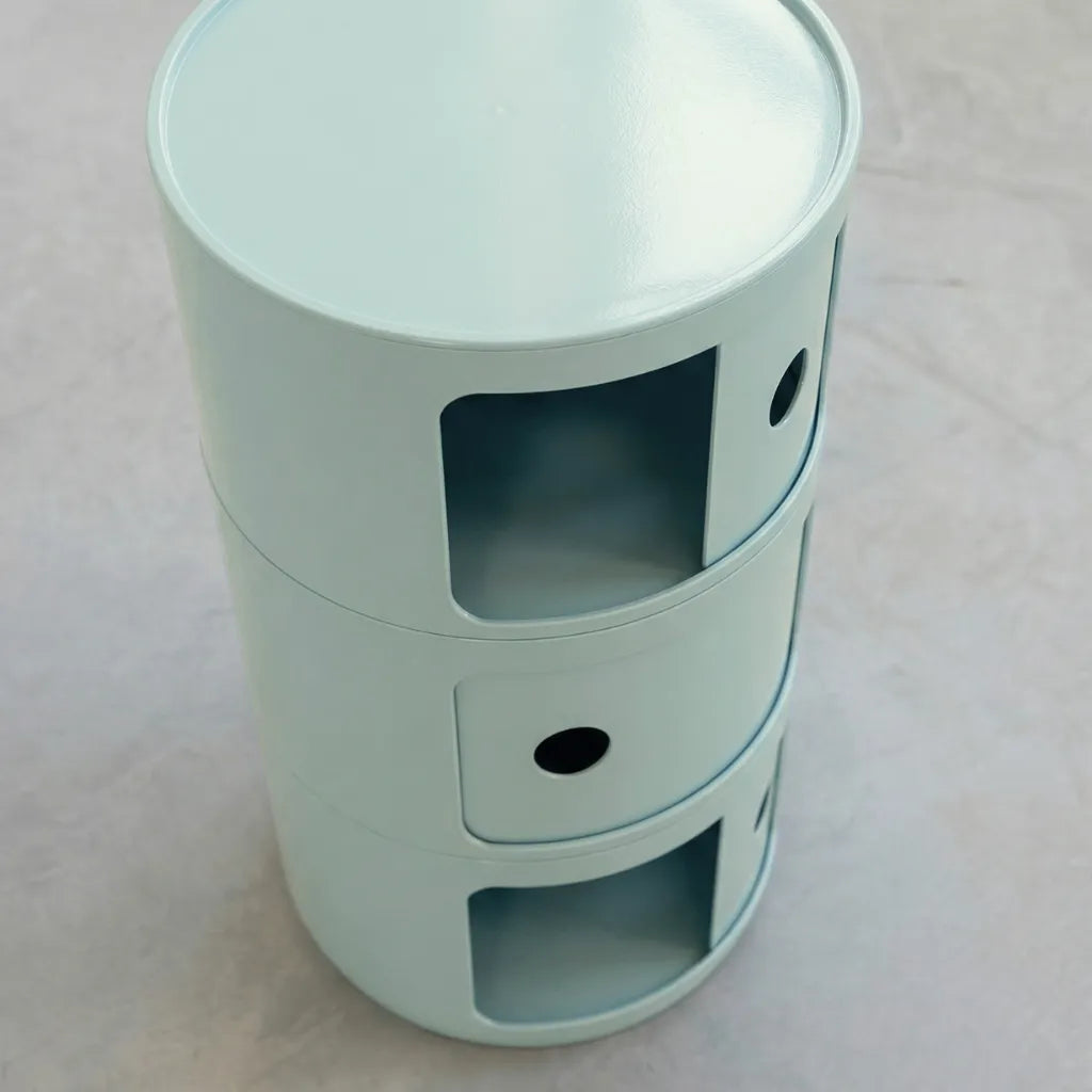 Kartell Componibili dupe round modular storage unit in light blue glossy plastic with three tiers on concrete floor in white studio