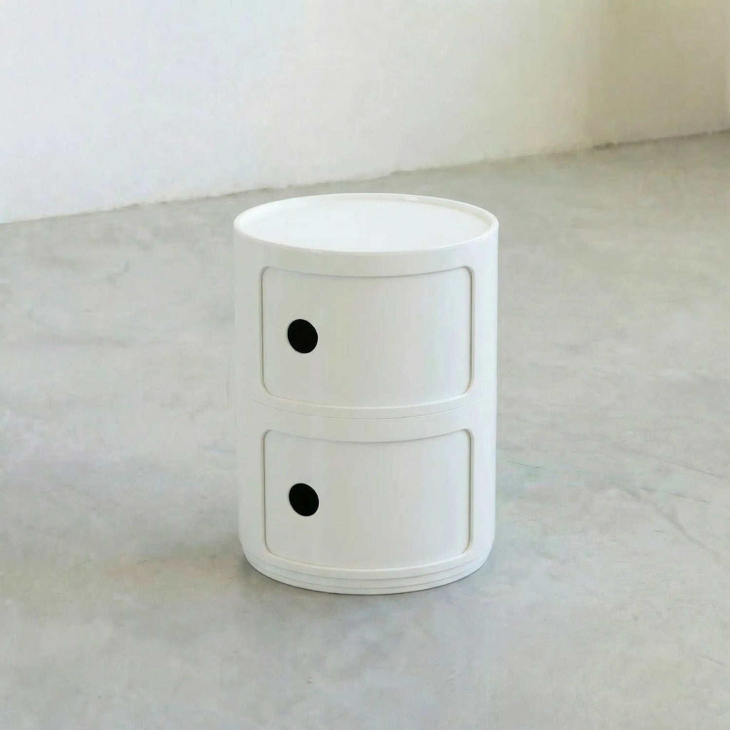 Kartell Componibili dupe round modular storage unit in white glossy plastic with two tiers on concrete floor in white studio