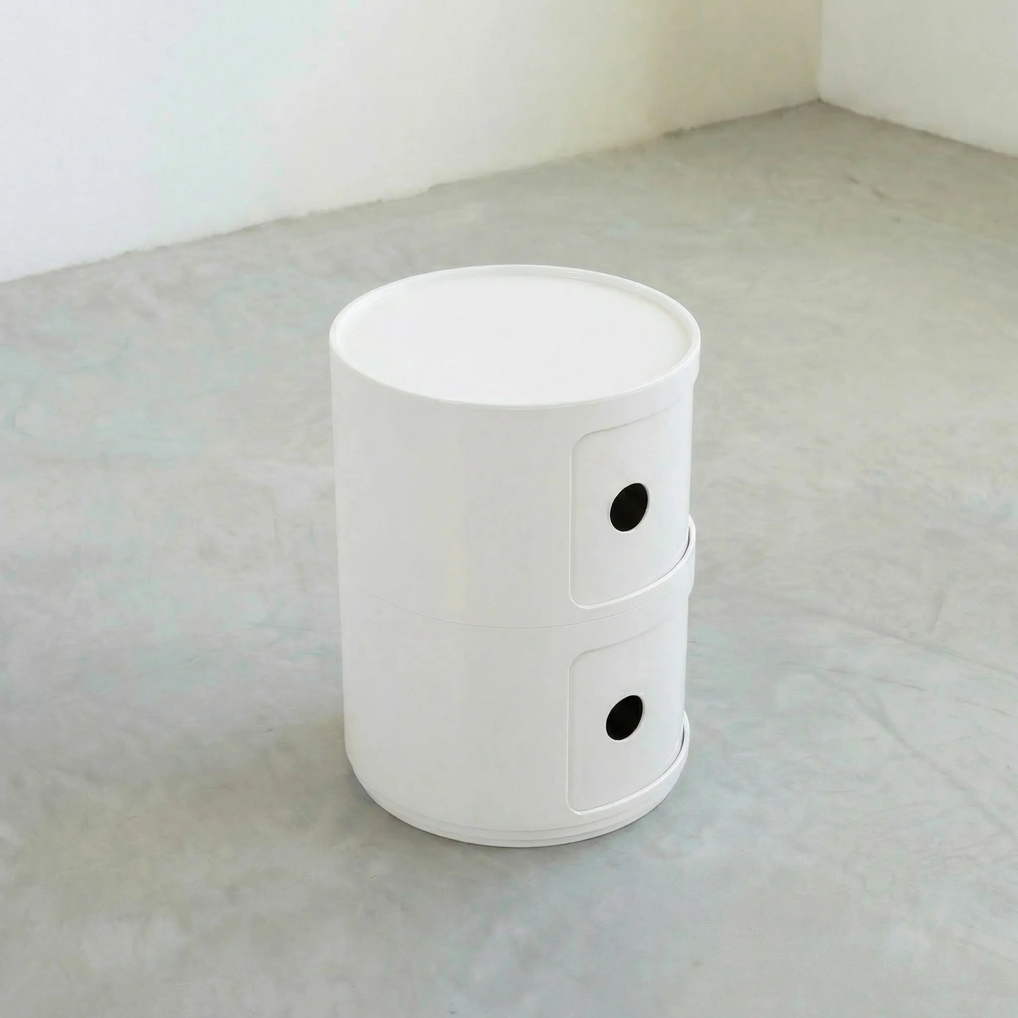 Kartell Componibili dupe round modular storage unit in white glossy plastic with two tiers on concrete floor in white studio