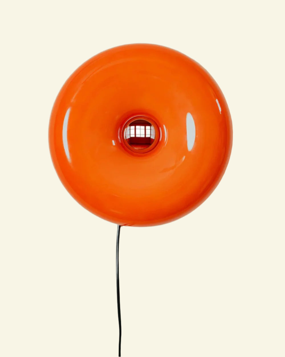 Bauhaus-style orange donut lamp on a tabletop, featuring three-color LED dimming and premium materials.