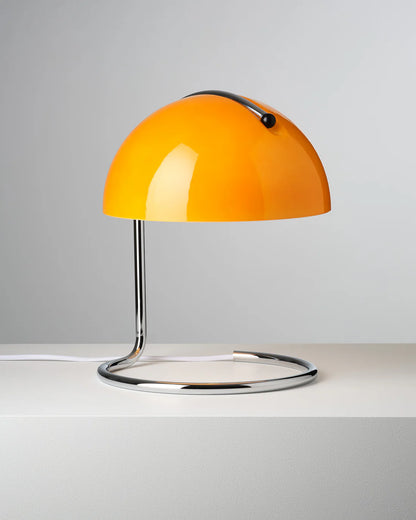 Orange table aromatherapy lamp with a metallic base on a white surface and gray background
