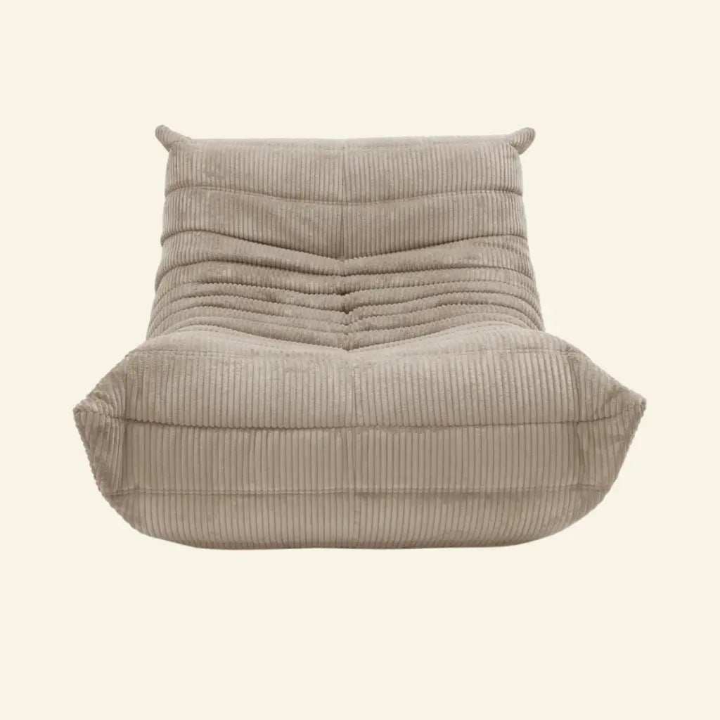 Beige togo styled chair in corduroy on a beige background