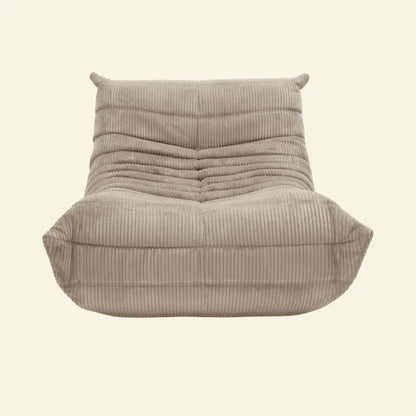 Beige togo styled chair in corduroy on a beige background