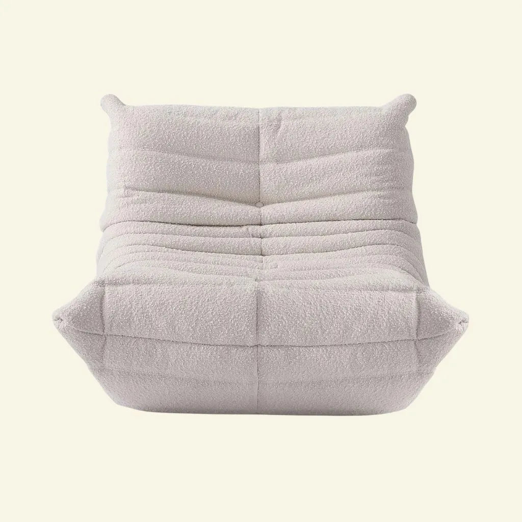 White Boucle togo chair replica on a light beige background