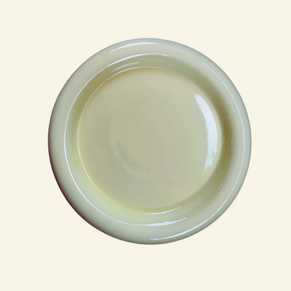 Round chunky thick ceramic plate on a beige background
