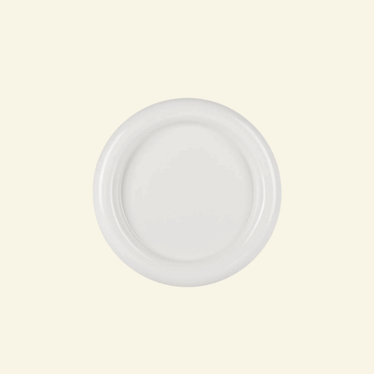 Round chunky thick ceramic plate in white  on a beige background