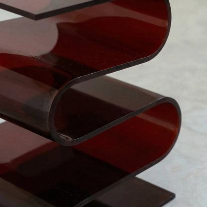 Close up of the Acrylic S Shaped Side Table in amber red  by Vibehaus