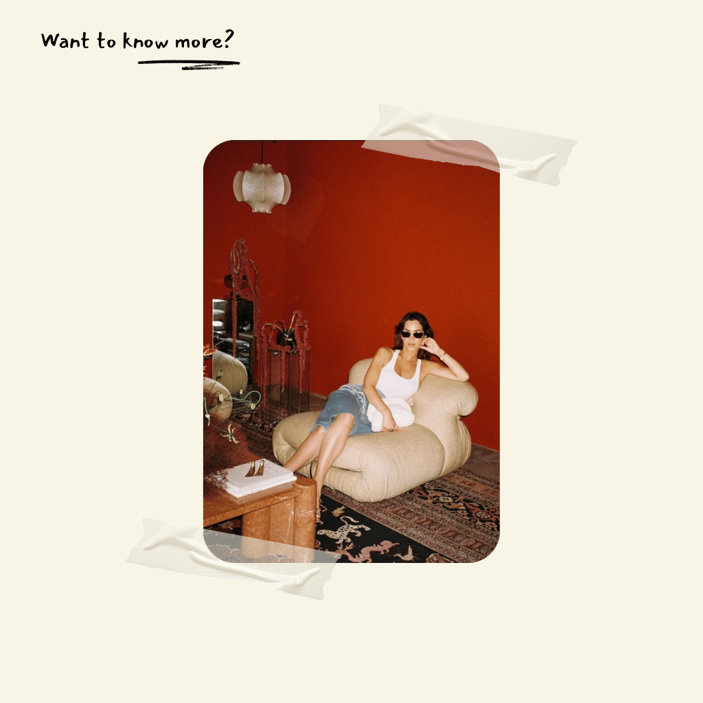 Woman sitting on a beige soriana armchair replica in a room with red walls.