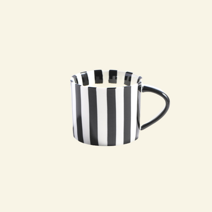 Black and white striped Artisan Ceramic Mug on a beige background
