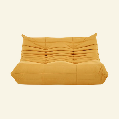 Togo-style 2-seater velvet sofa in yellow with low-profile design, plush channel tufting, and sculptural curves — inspired by Michel Ducaroy, ideal for modern interiors.