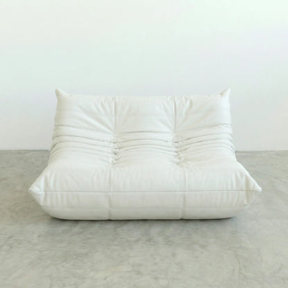 White togo leather sofa dupe on a gray floor with a white wall background