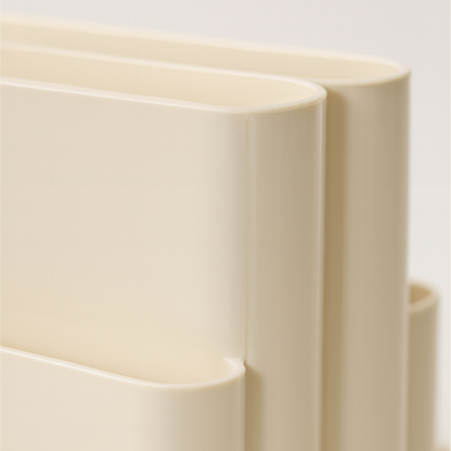 Close-up of beige cascade magazine rack on a light background