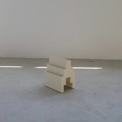 White Kartell magazine rack replica on a white surface