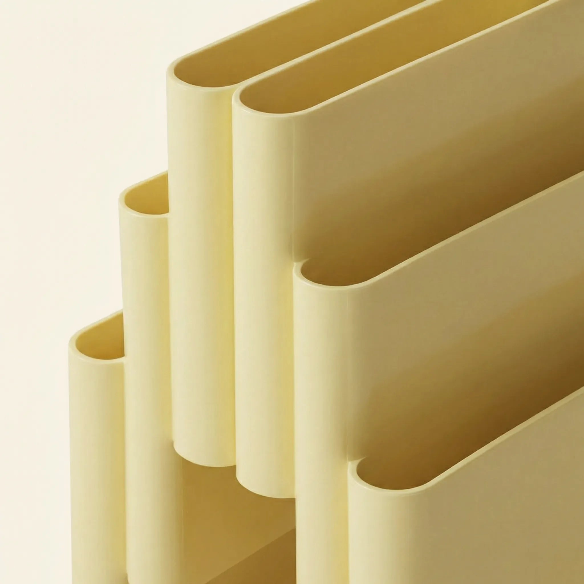 Close up of the Yellow Kartell magazine rack replica on a white surface