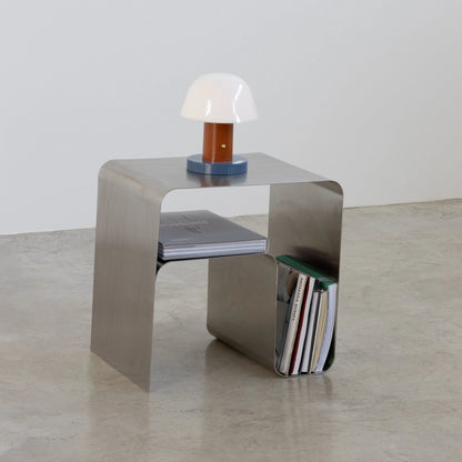 Modern bauhaus metal side table with a lamp and books on a neutral background by vibehaus