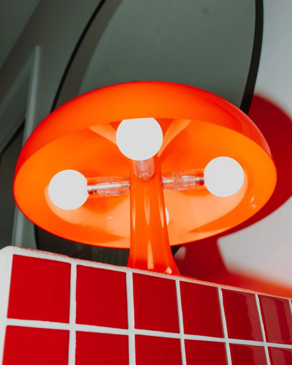 Bella table lamp in bold orange, mushroom-shaped design, retro-style lighting for modern interiors.