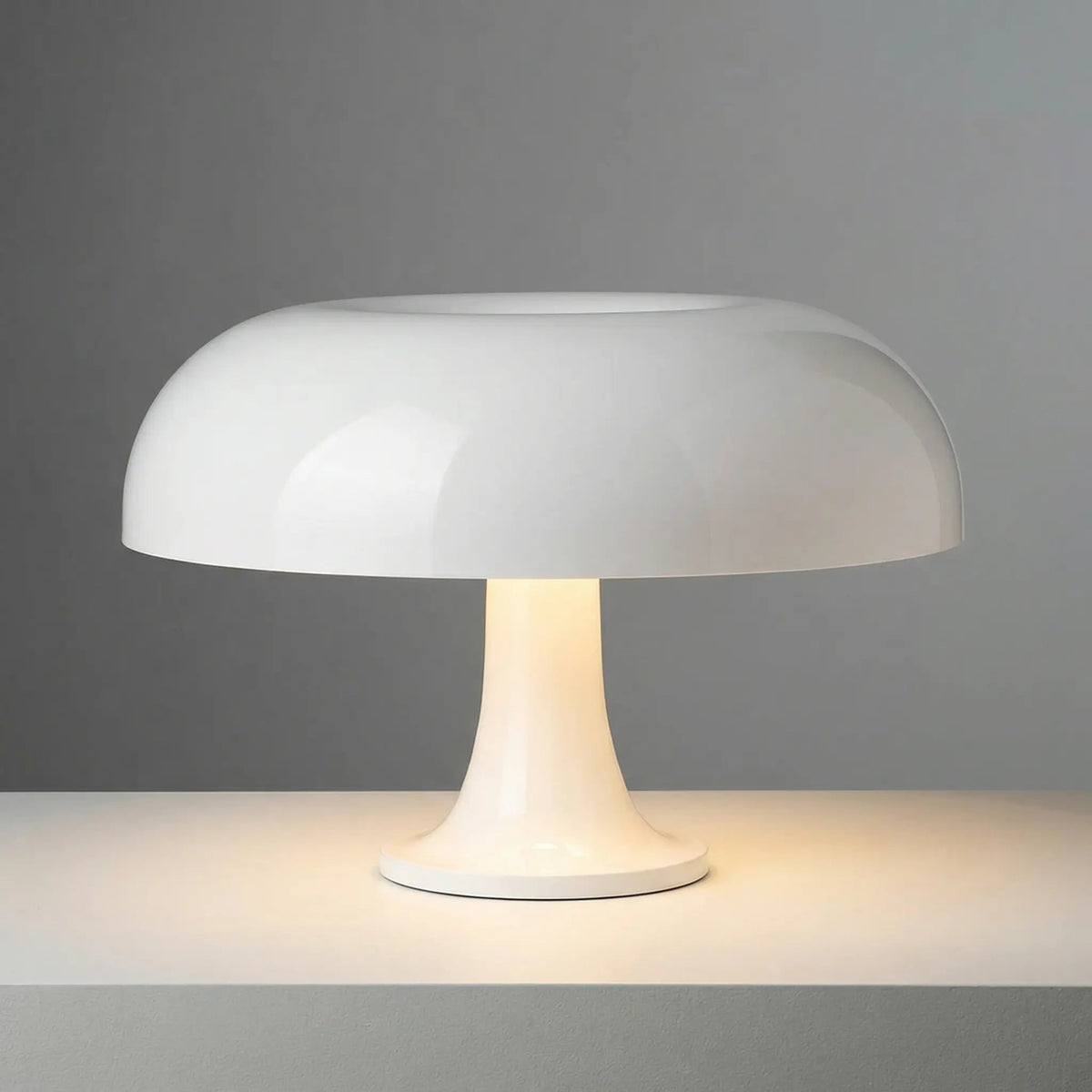White Bella table lamp on a gray surface with a gray background