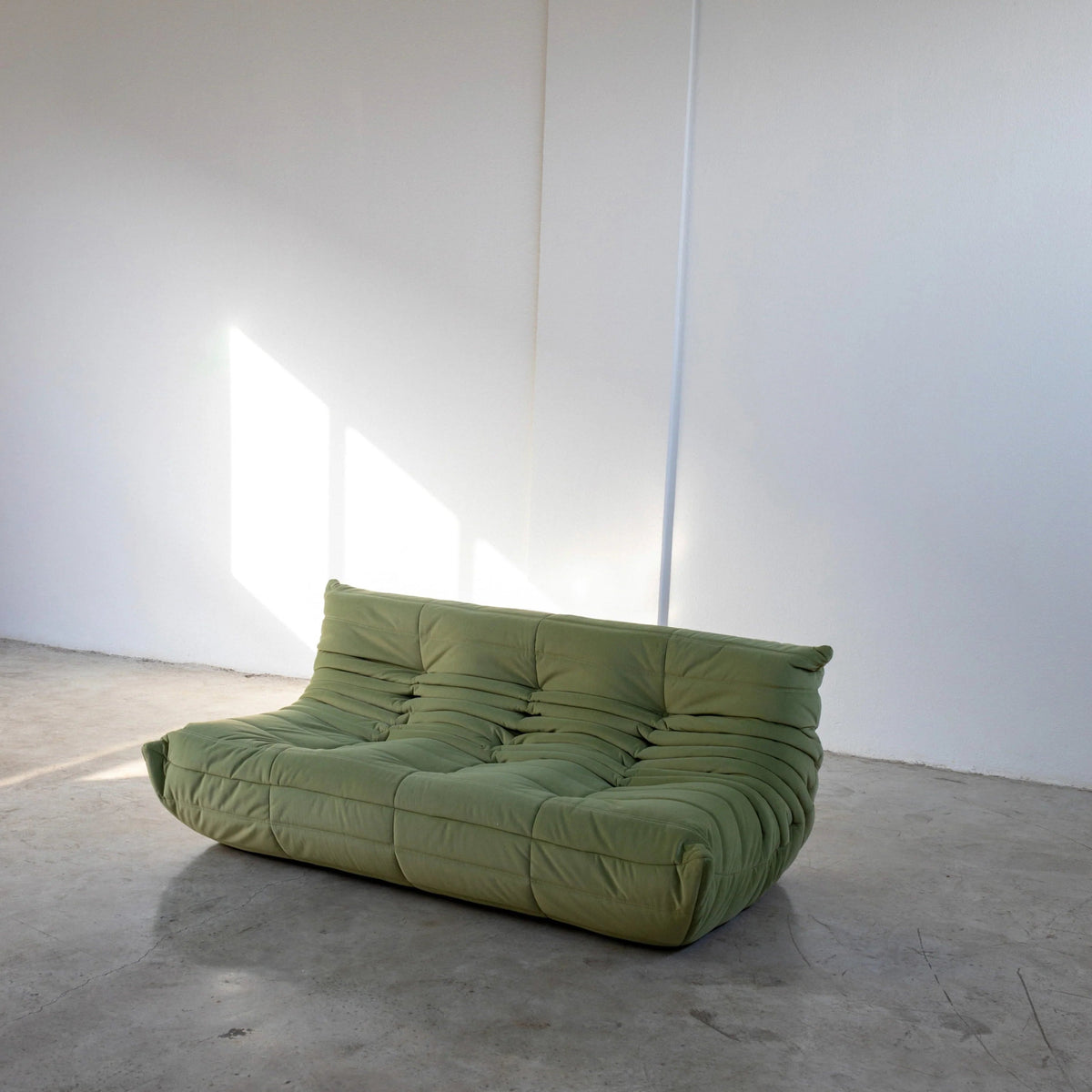 Bruma 3 seater sofa in Green Velvet Suede by vibehaus on a concrete floor