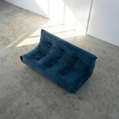 Bruma 3 seater sofa in dark blue Velvet Suede by vibehaus on a concrete floor, photographed from a top angle.