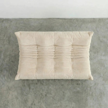 Bruma 3 seater sofa in cream Corduroy by vibehaus on a concrete floor, photographed from a top angle.