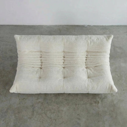 Bruma 3 seater sofa in white bouclé by vibehaus on a concrete floor, photographed from a top angle.