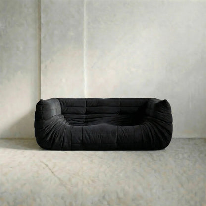 Bruma sofa with armrests in black on a white background on a light gray floor with a neutral wall background