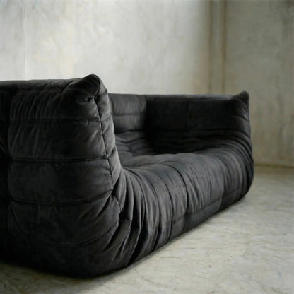 Bruma sofa with armrests in black against a neutral wall