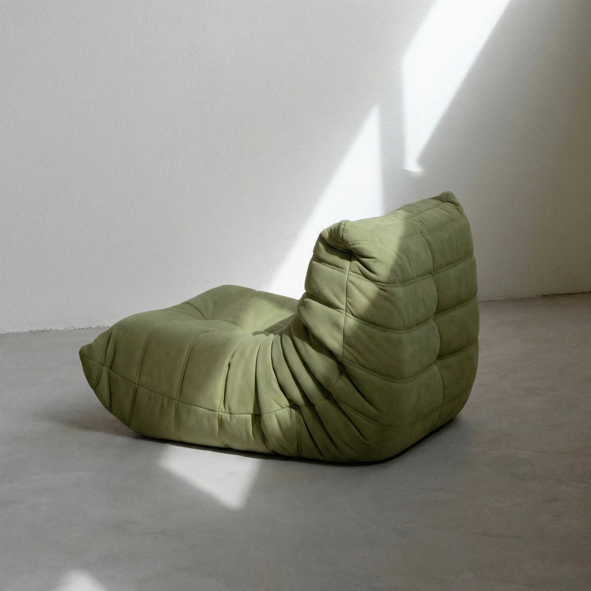 Bruma Chair in green velvet suede on concrete floor by vibehaus