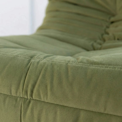 Close-up of the Bruma chair in green velvet suede fabric.