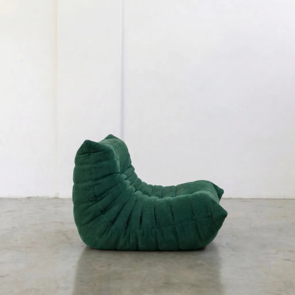 green corduroy Bruma-chair – low, frameless design with plush channel tufting