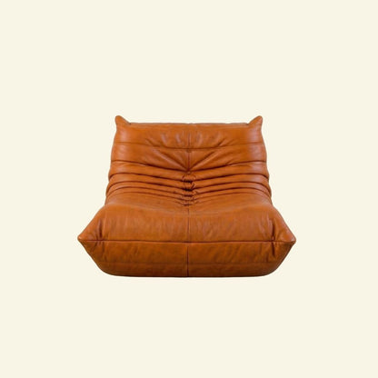 Bruma Chair in cognac real cowhide leather on a beige background by vibehaus