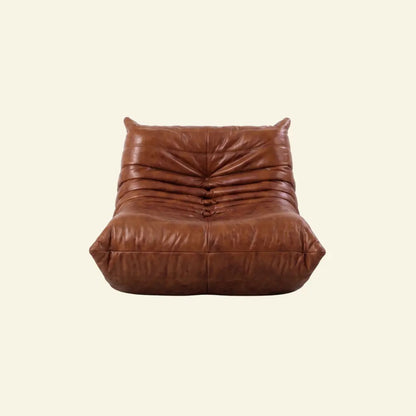 Bruma Chair in brown real oil wax leather on a beige background by vibehaus