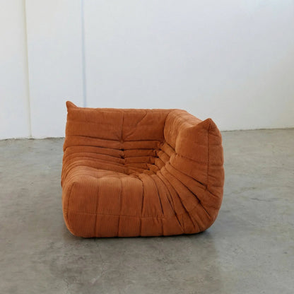 Bruma Sofa Corner in orange corduroy photographed from the front angle.