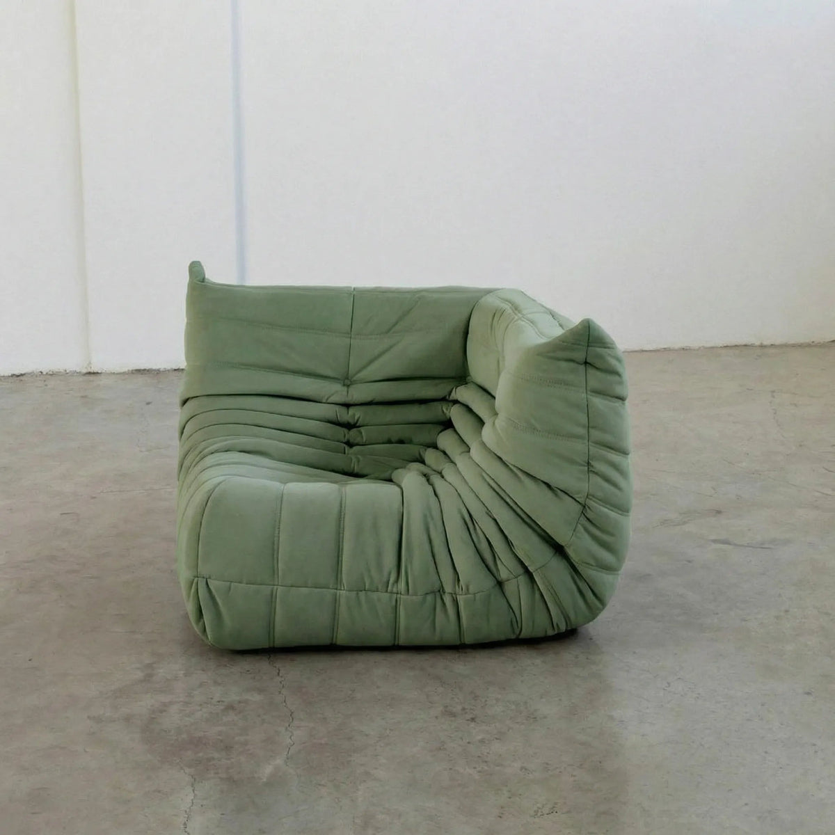 Bruma Sofa Corner in green velvet suede photographed from the front angle.