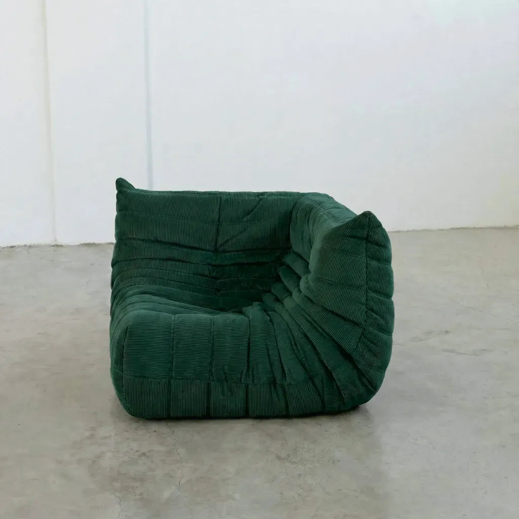Bruma Sofa Corner in dark green corduroy photographed from the front angle.