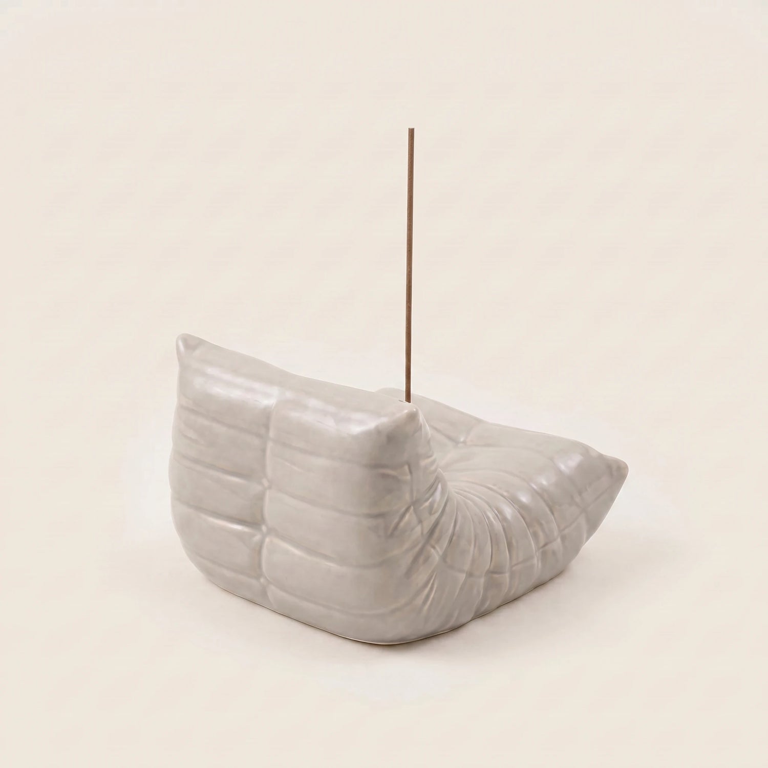 Grey Bruma incense holder from the back angle, showing its pleated chair silhouette and metal incense insert.