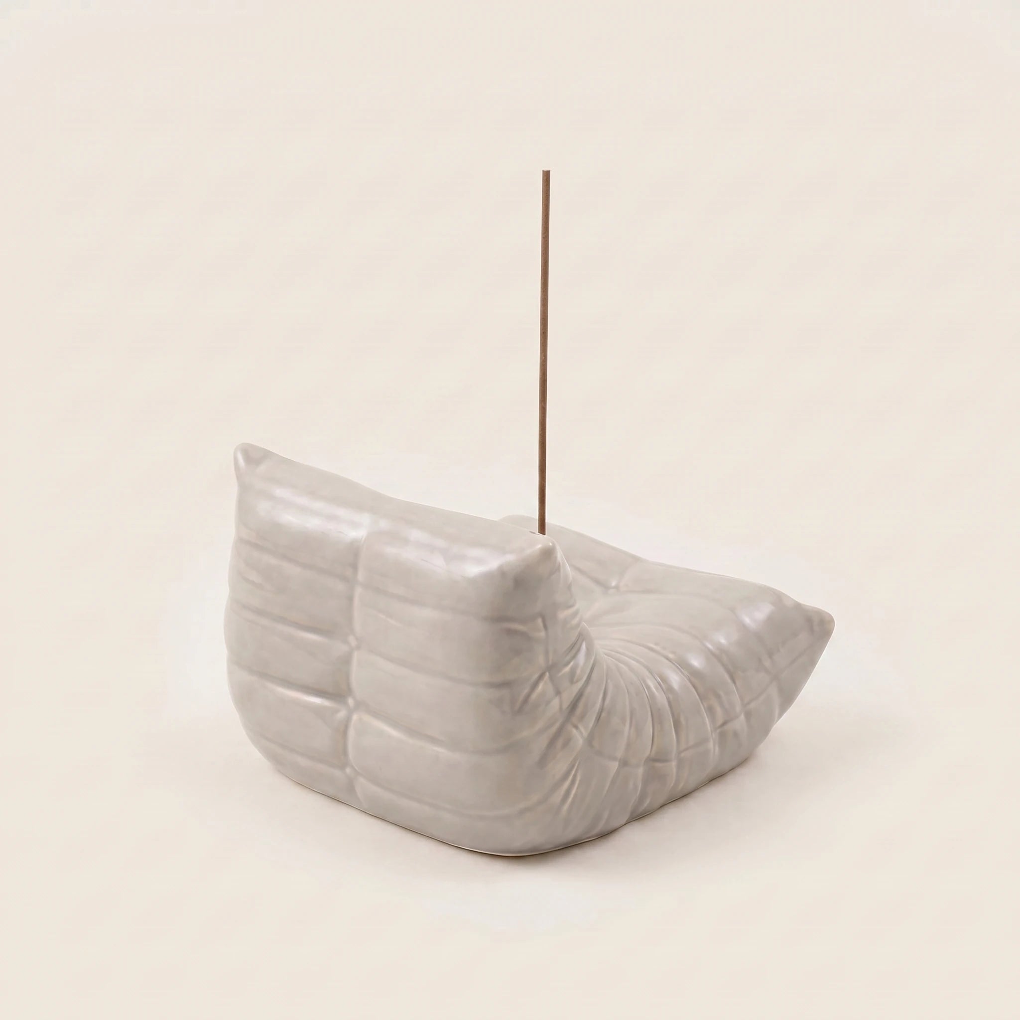 Grey Bruma incense holder from the back angle, showing its pleated chair silhouette and metal incense insert.