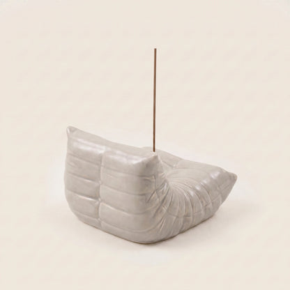 Grey Bruma incense holder from the back angle, showing its pleated chair silhouette and metal incense insert.