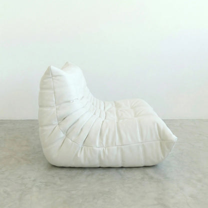 White Bruma leather sofa on a gray floor with a white wall background
