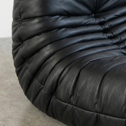 Close-up of a black leather Bruma sofa with a textured surface.