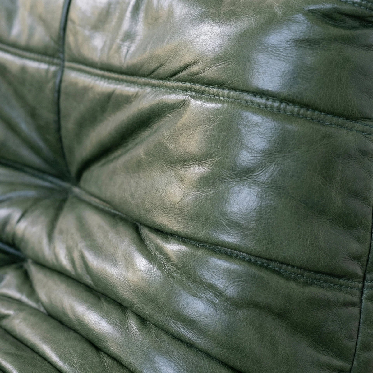 Close-up of the green oil wax leather of the Bruma Chair by vibehaus