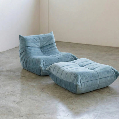 Blue velvet suede Bruma chair and ottoman by Vibehaus on a concrete floor