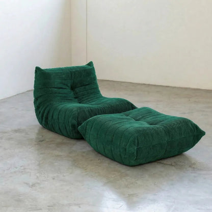 Bruma chair and ottoman in dark green corduroy by Vibehaus on a concrete floor