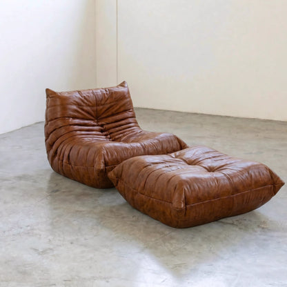 Brown Bruma leather ottoman and chair in a studio setting