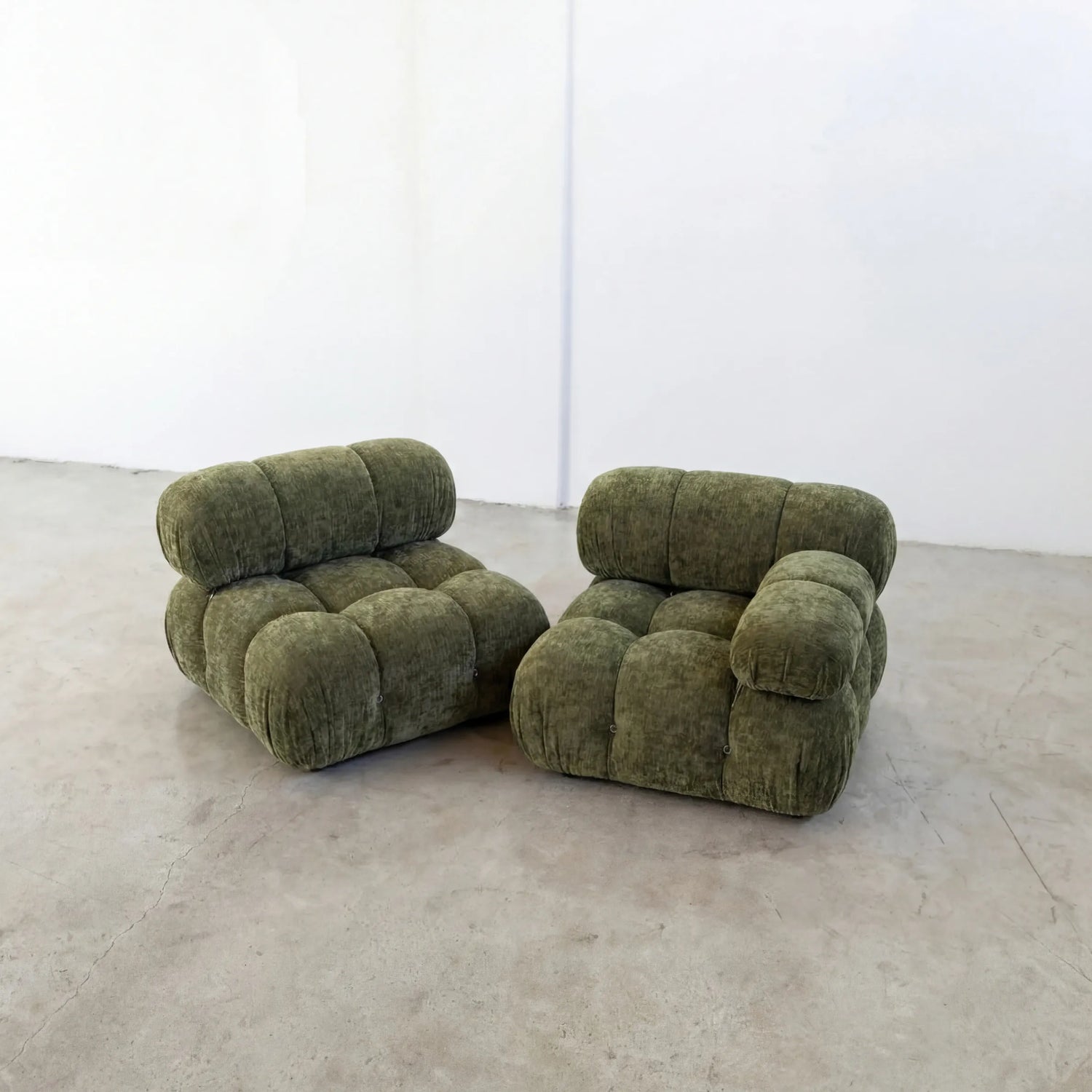 Pair of Green camaleonda inspired armchairs in chenille on a white floor with a white wall background