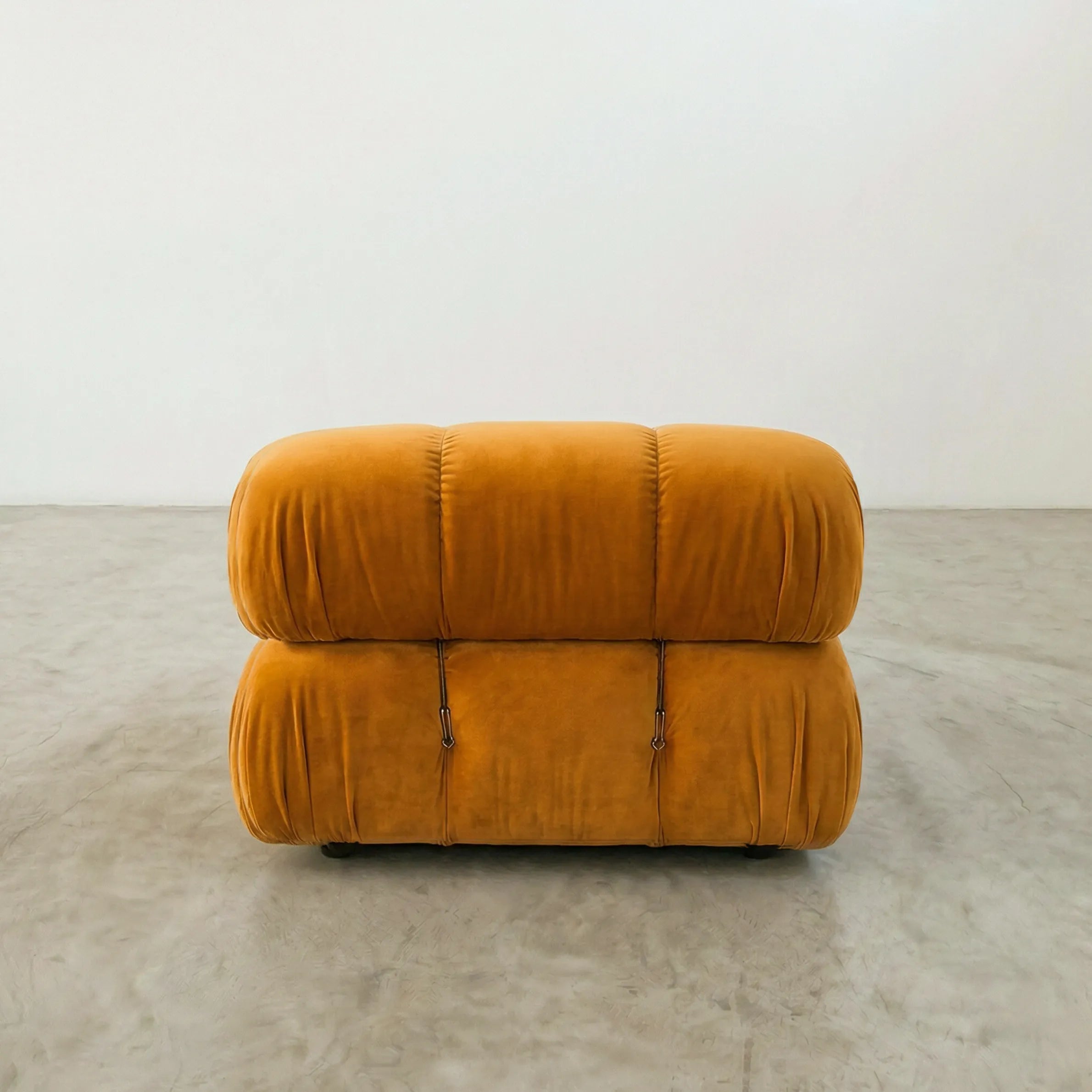 Mustard camaleonda chair dupe on a gray floor with a white wall background