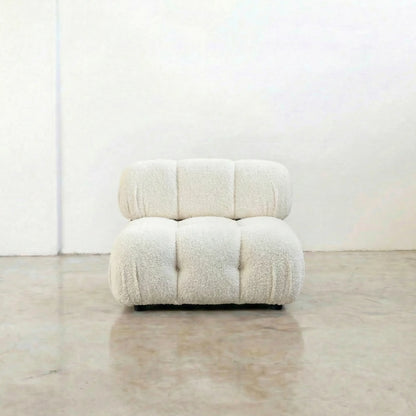 camaleonda dupe armchair in white boucle on a reflective floor with a white wall background
